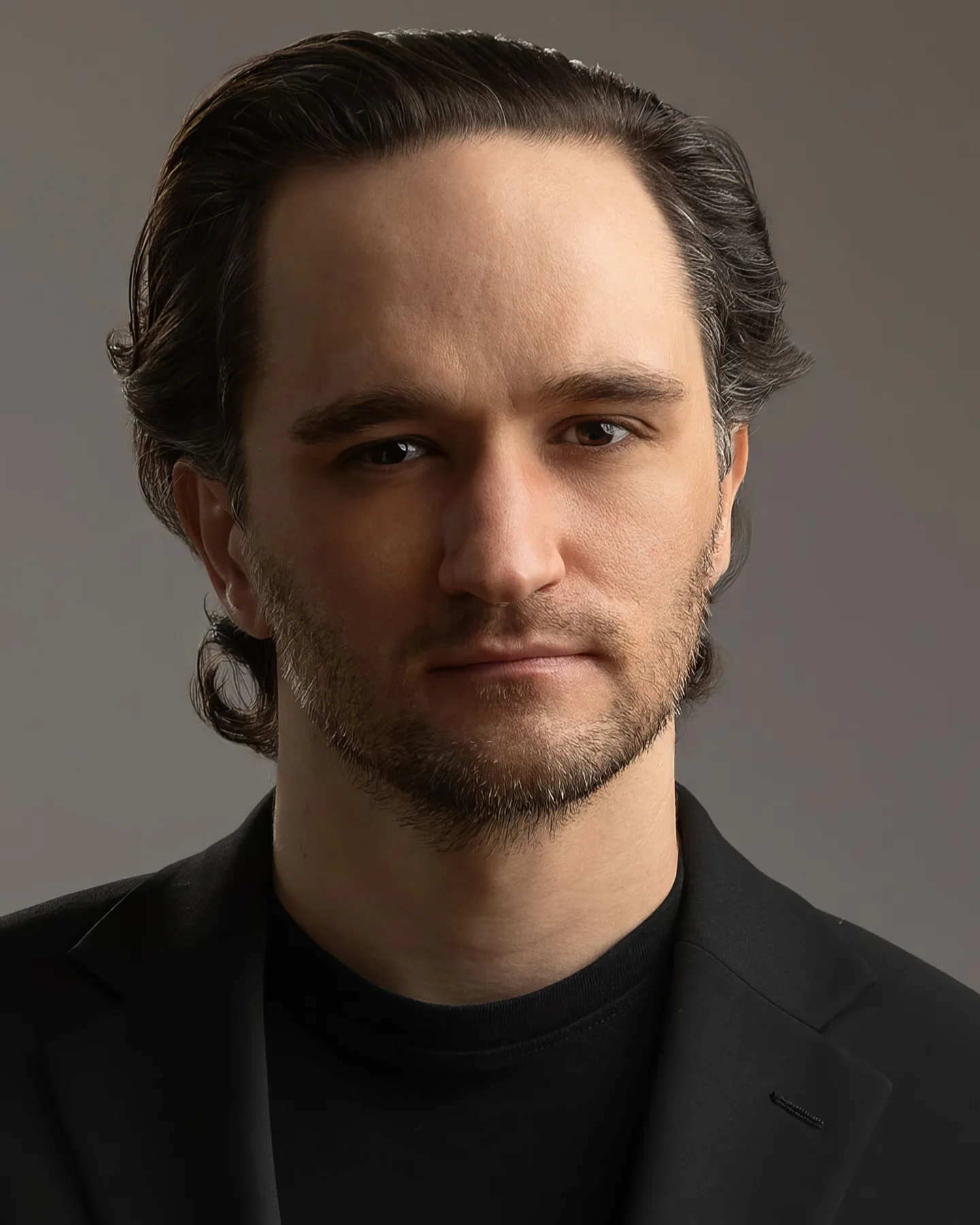 Theatrical headshot of Jacques du Plessis in a black jacket